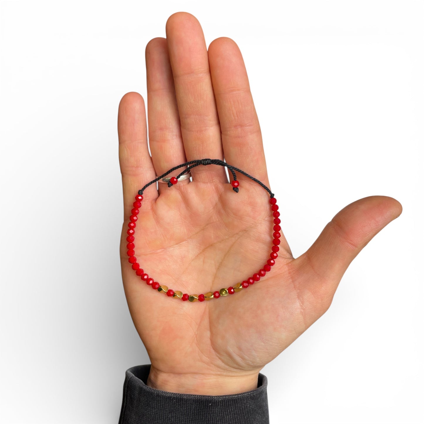 handgefertigtes-tibetisches-armband-rot-messing-auf-handflaeche-praesentiert