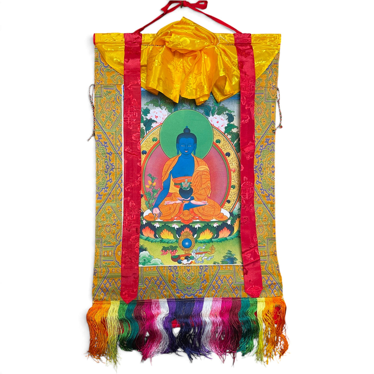Rotolo thangka Buddha della Medicina con broccato giallo oro, nastri di seta rossi e frange colorate, vista d'insieme