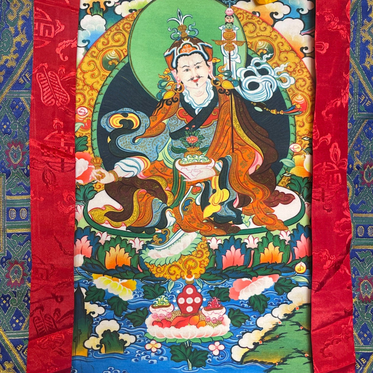 Primo piano del motivo di Guru Rinpoche sul thangka con cappello di loto e vajra