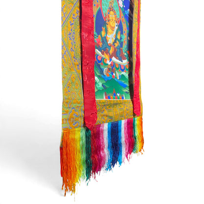 Dettaglio delle frange colorate e della cornice in broccato del thangka Dzambala giallo
