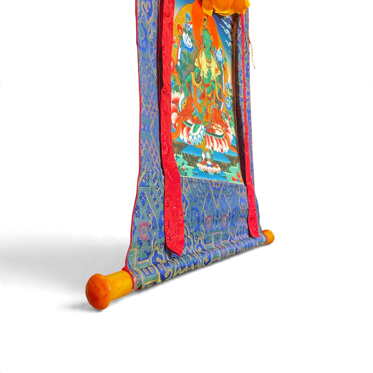 Thangka Tara verte, détail de la barre aux extrémités orange et du brocart – Himalaya Vibes