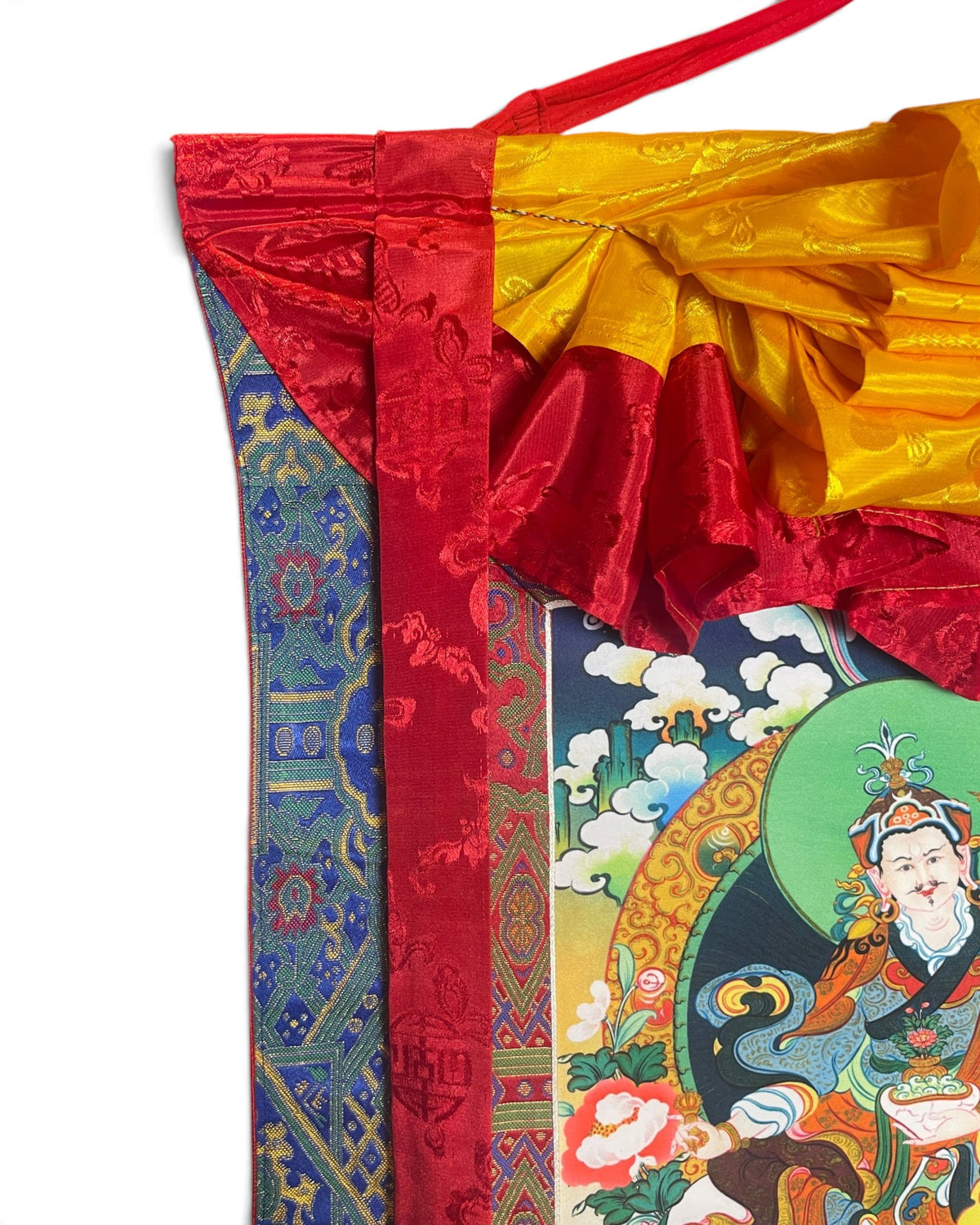 Dettaglio in alto: grembiule di seta gialla e nastri di seta rossi del thangka Guru Rinpoche