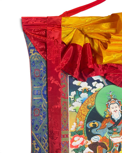 Dettaglio in alto: grembiule di seta gialla e nastri di seta rossi del thangka Guru Rinpoche