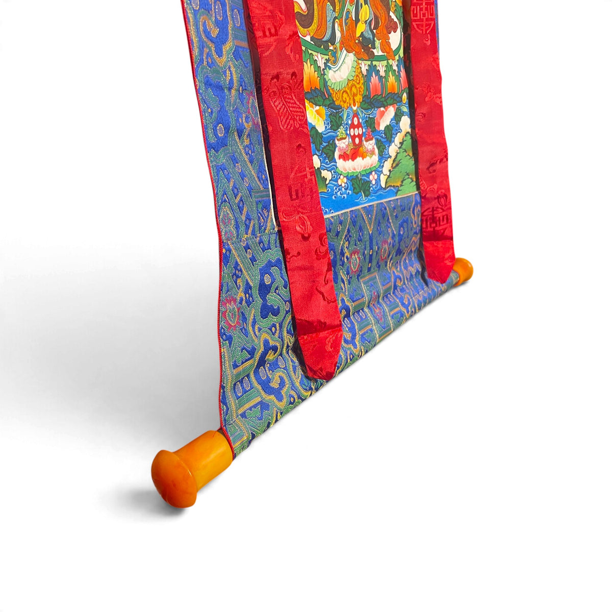 Thangka Guru Rinpoche, dettaglio dell'asta con estremità arancioni e broccato – Himalaya Vibes