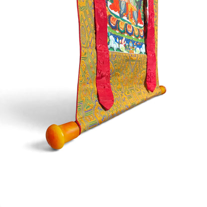 Thangka Manjushri, détail de la barre aux extrémités orange et du brocart – Himalaya Vibes