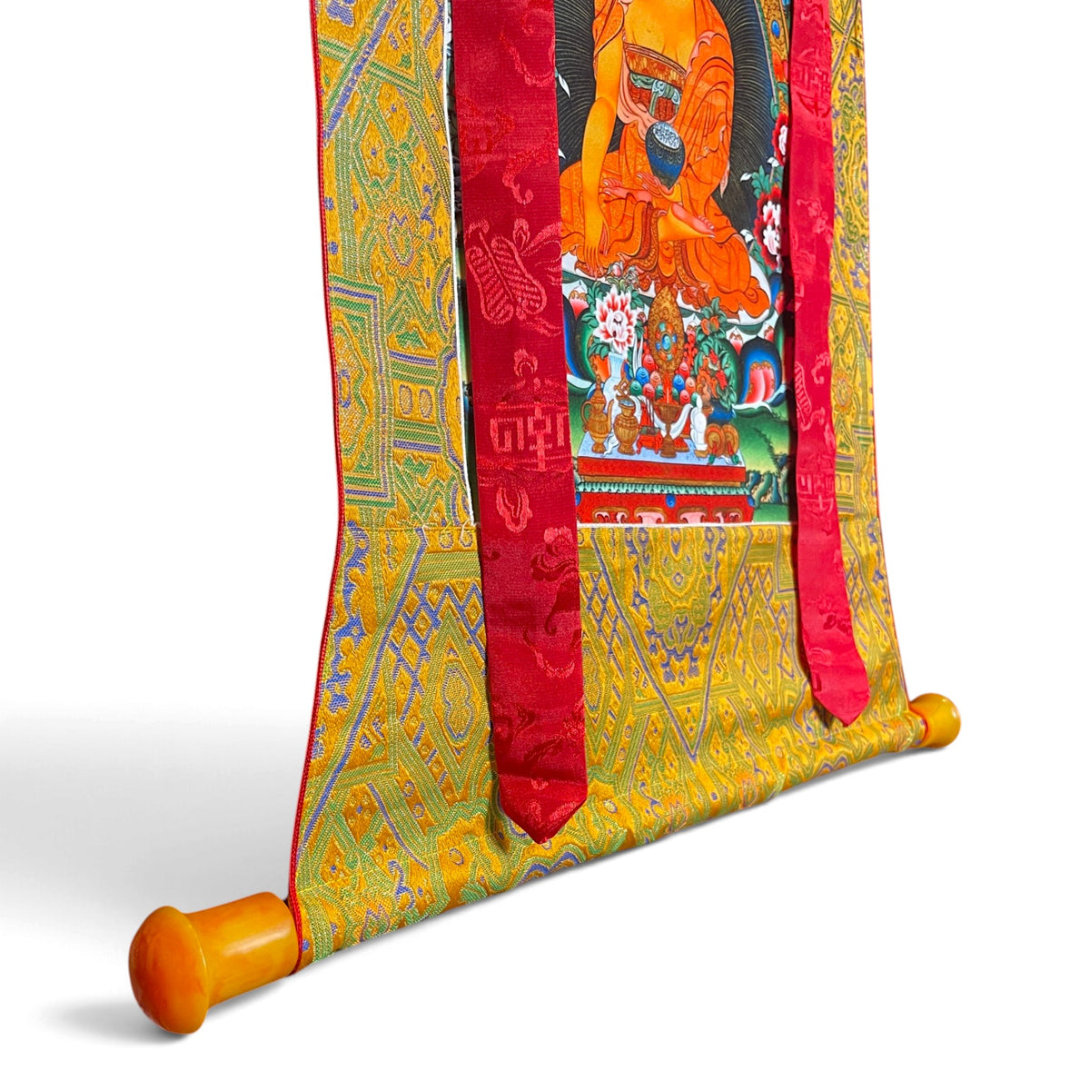 Détail de la barre aux extrémités orange et du brocart, thangka Bouddha Shakyamouni – Himalaya Vibes