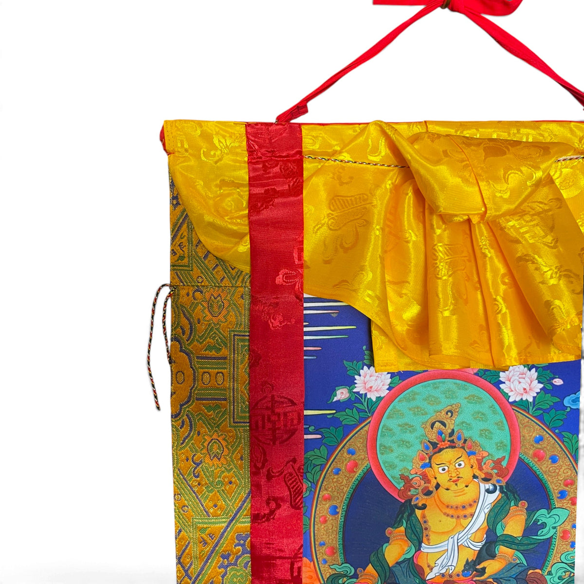 Dettaglio del grembiule di seta giallo e dei nastri di seta rossi del thangka Dzambala giallo