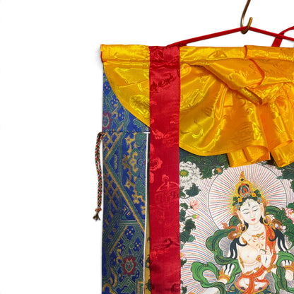 Dettaglio del grembiule di seta giallo con broccato in alto sul thangka Tara bianca