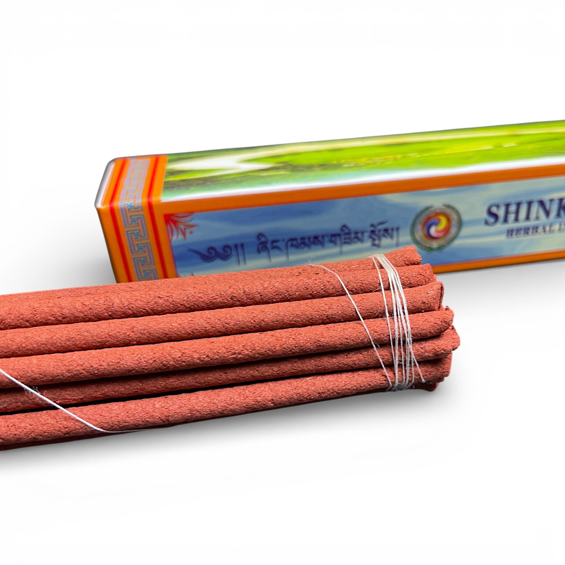 Detailansicht: Shinkham Herbal Incense Stäbchen neben der dekorativen orangefarbenen Box – Tibet Laden Bern.