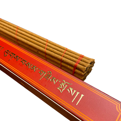 Detailansicht der handgerollten Lug-Sam Räucherstäbchen ohne Holzkern neben der Verpackung.