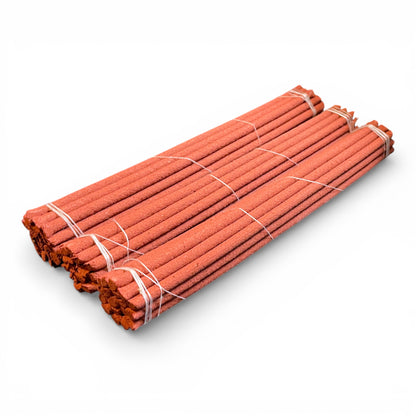 Nahaufnahme der dicken, rötlichen tibetischen Räucherstäbchen, mit weißem Faden gebündelt.