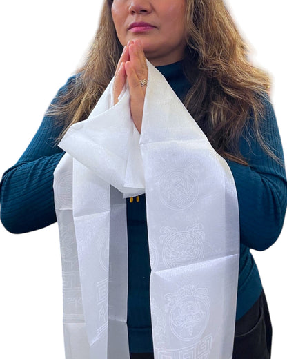 Frau in Anjali Mudra (Gebetshaltung) mit einem Khata Schal über den Händen, zeigt Respekt.