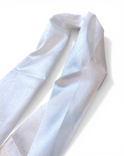 Traditioneller weißer Khata Schal mit gewebten Glückssymbolen, leicht gefaltet auf weißem Hintergrund.