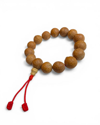 Detailaufnahme eines tibetischen Mala Armbands aus Bodhi Samen mit roter Schnur