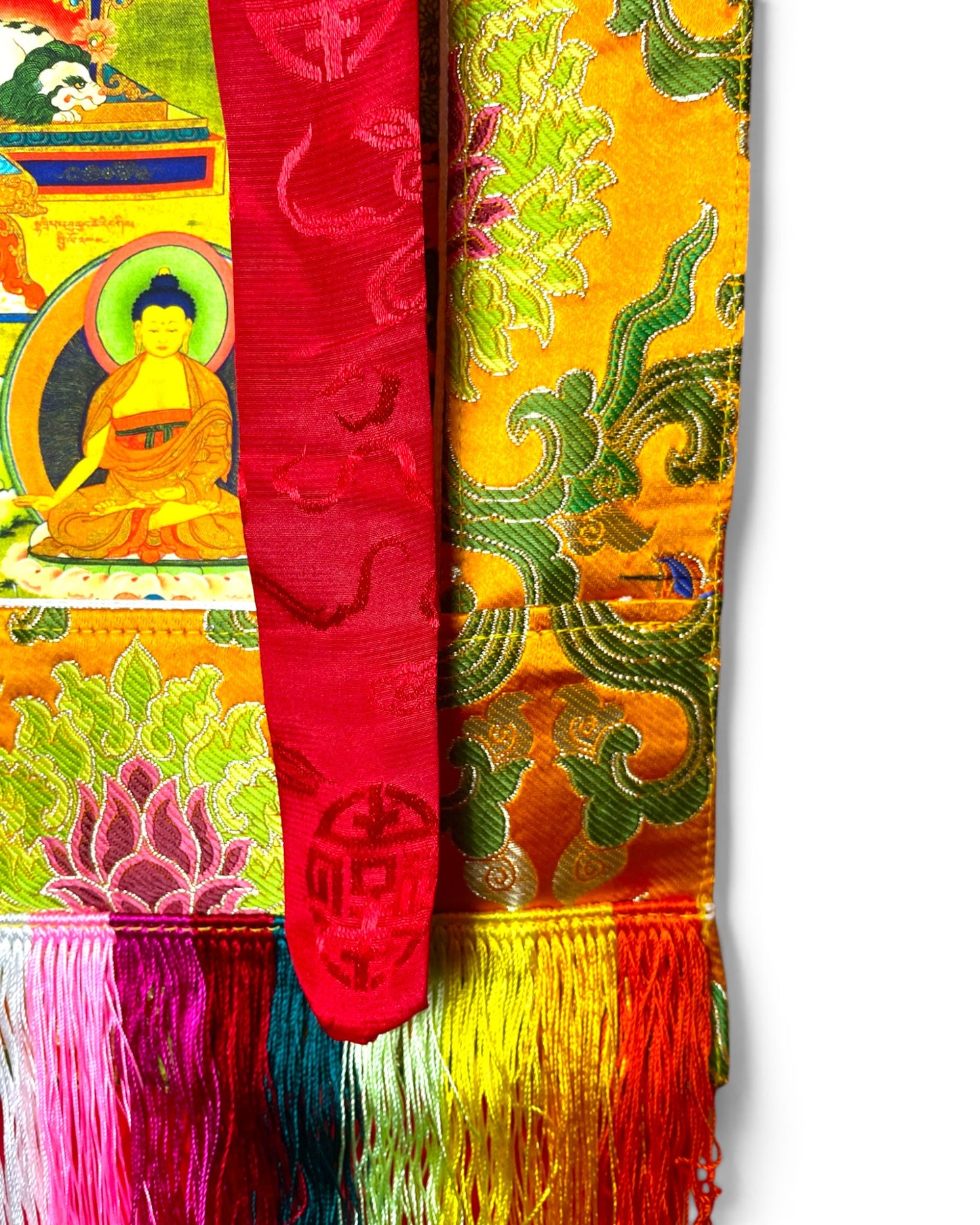 Detailaufnahme des roten Zierbandes und des gelben Brokatrahmens mit Lotus-Motiven.