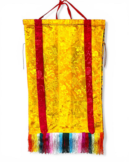 Rückseite des Medizin-Buddha Thangkas aus gelber Seide mit traditionellen Mustern.