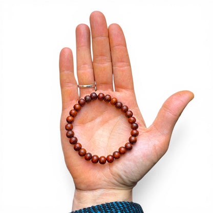 Handfläche mit Sandelholz Mala Armband, präsentiert im Himalaya Vibes Shop