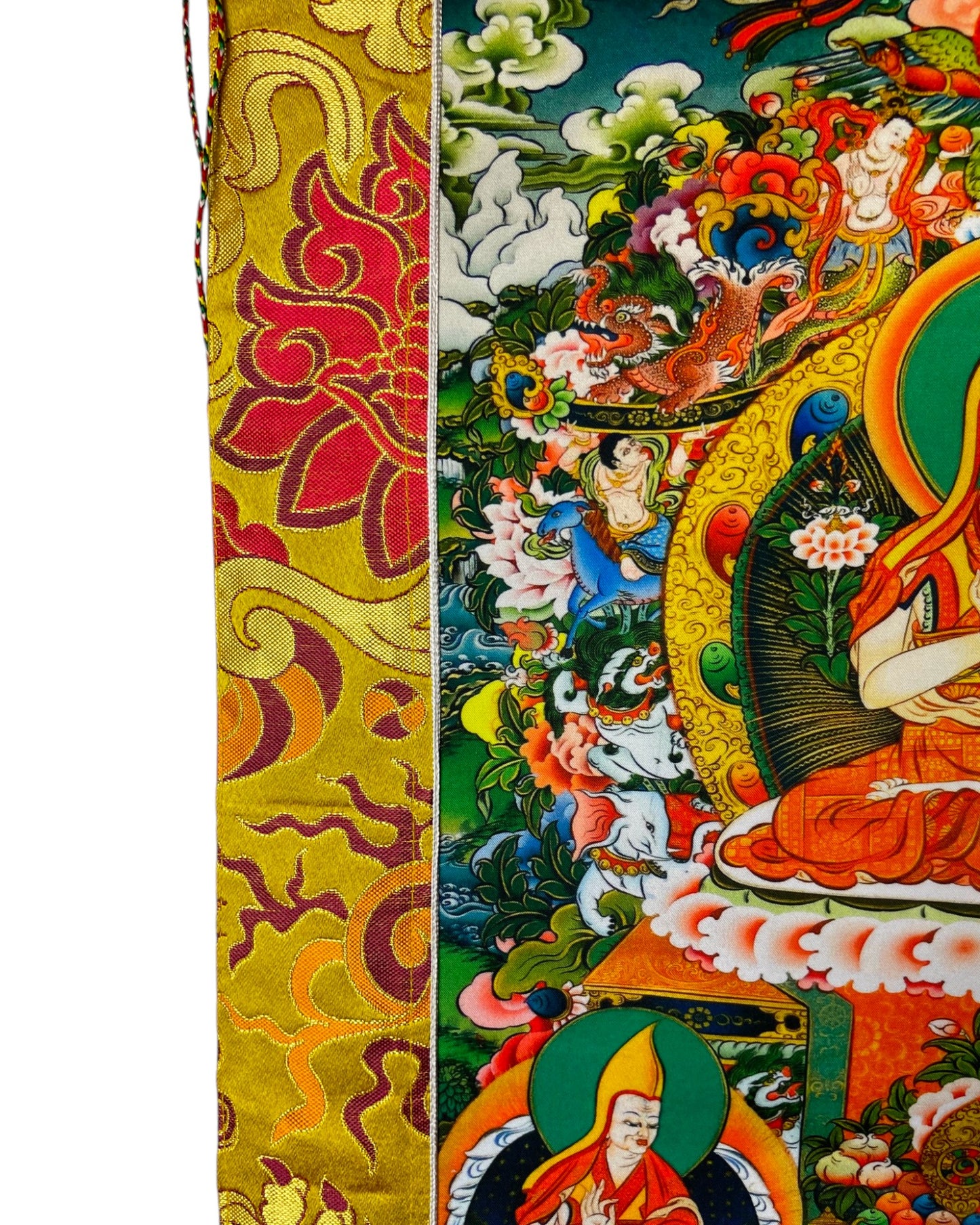 Detail des goldenen Seidenbrokats mit traditionellen tibetischen Mustern am Rand des Thangkas.