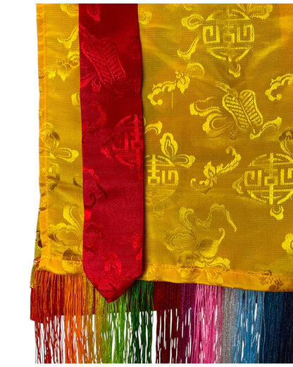 Nahaufnahme des gelben und roten Seidenbrokats mit Regenbogen-Fransen am Tibetischen Thangka – Himalaya Vibes Bern.
