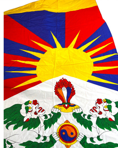 Nahaufnahme der Symbole: Schneeloewe und strahlende Sonne auf der Tibet Flagge