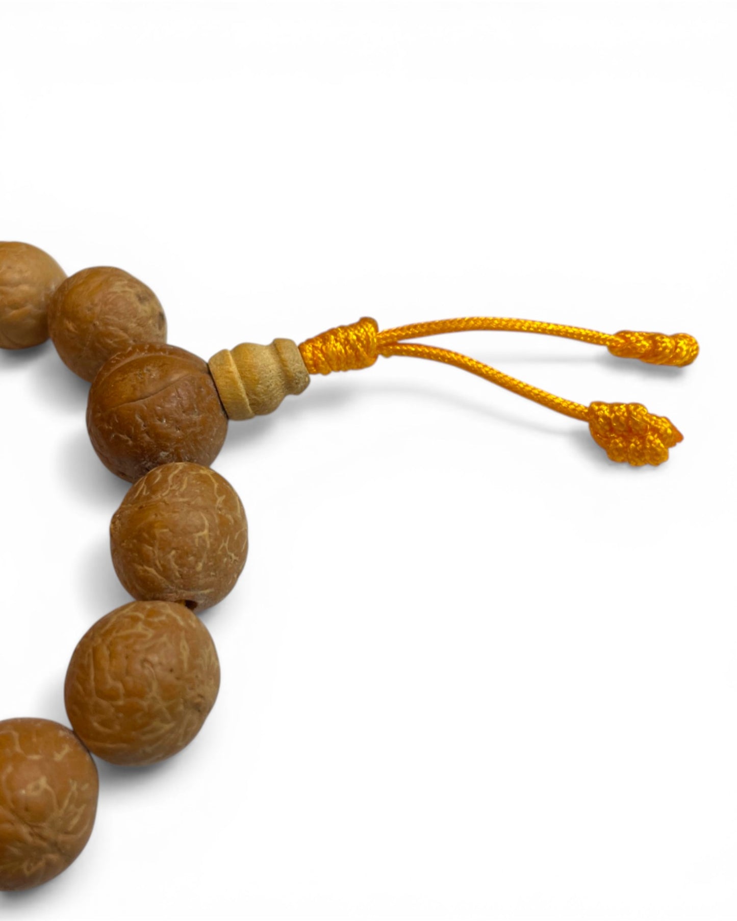 Nahaufnahme des Tibetischen Bodhi Samen Armbands mit gelber Kordel und Guru-Perle.