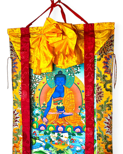 Detailansicht des tibetischen Medizin-Buddha Thangkas mit gelber Seidenabdeckung.
