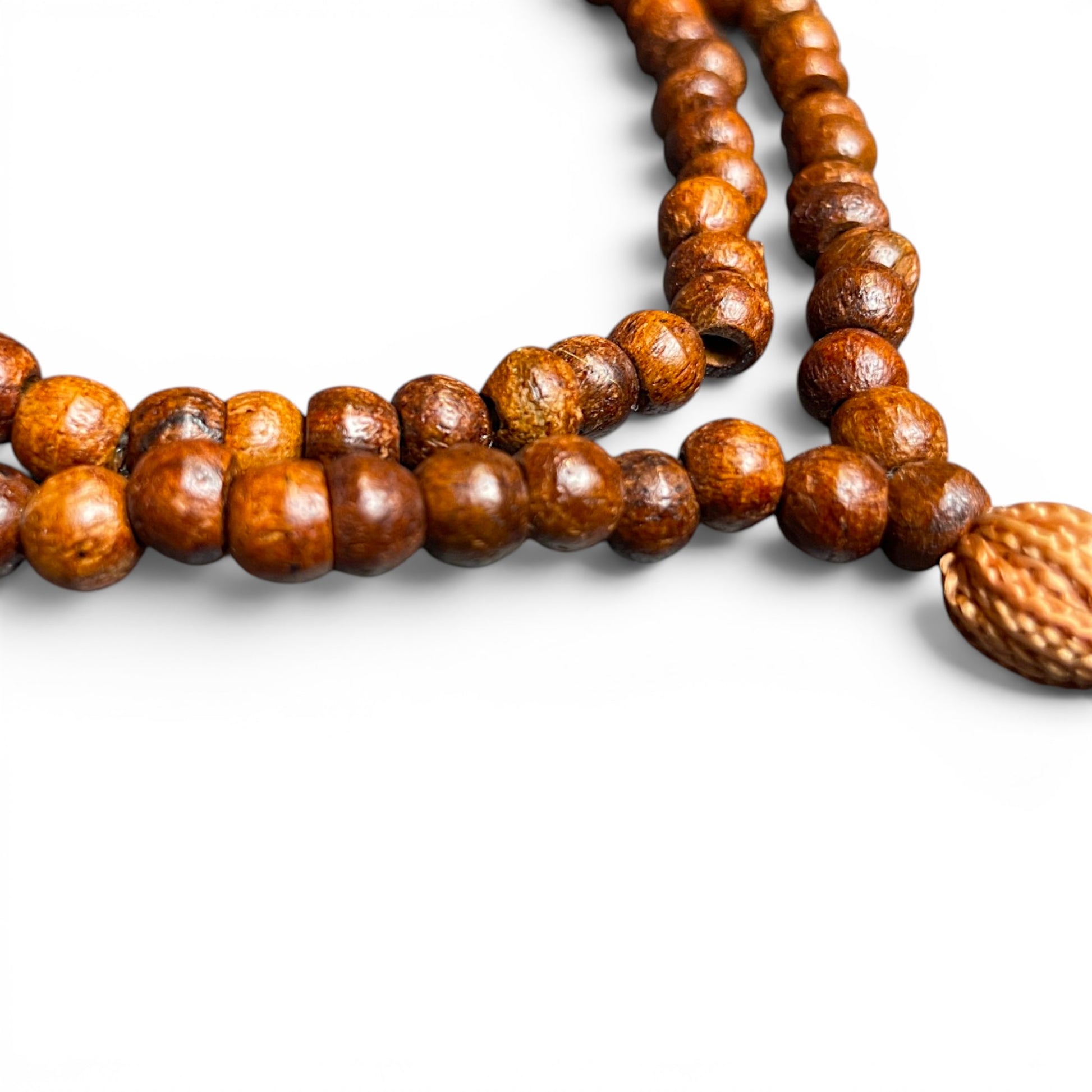 Nahaufnahme der Holzperlen einer Tulsi-Mala (Heiliges Basilikum) mit natürlicher Maserung – Himalaya Vibes Bern